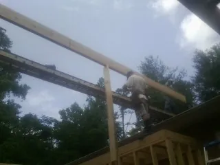 Carpenter setting a ridge beam over a new addition frame — Ice Dam Removal by Roofing Brothers in Waymart