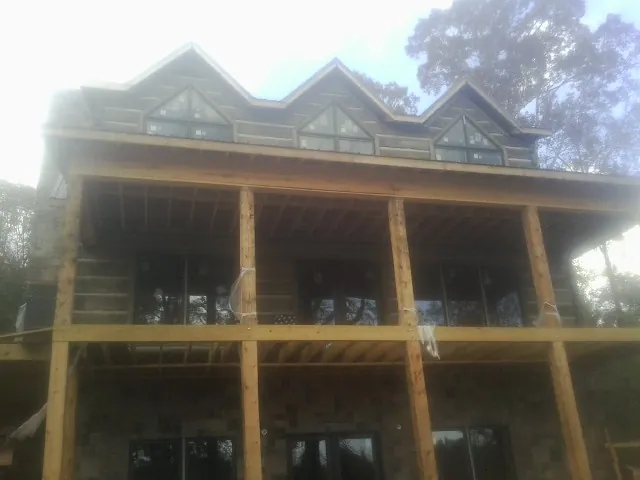 Dormers and porch framing on a large log home under construction — Roof Coating work by our crew in Waymart
