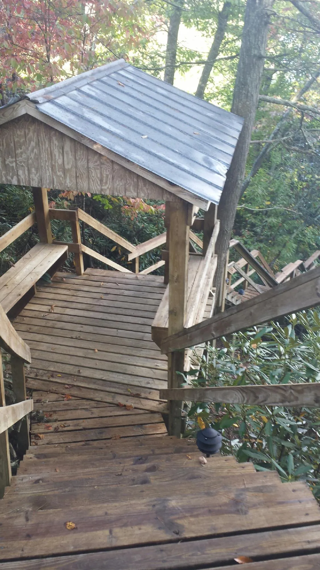 Metal roofed shelter over wooden steps on a wooded walkway — Skylight Repair & Installation work by our crew in Waymart