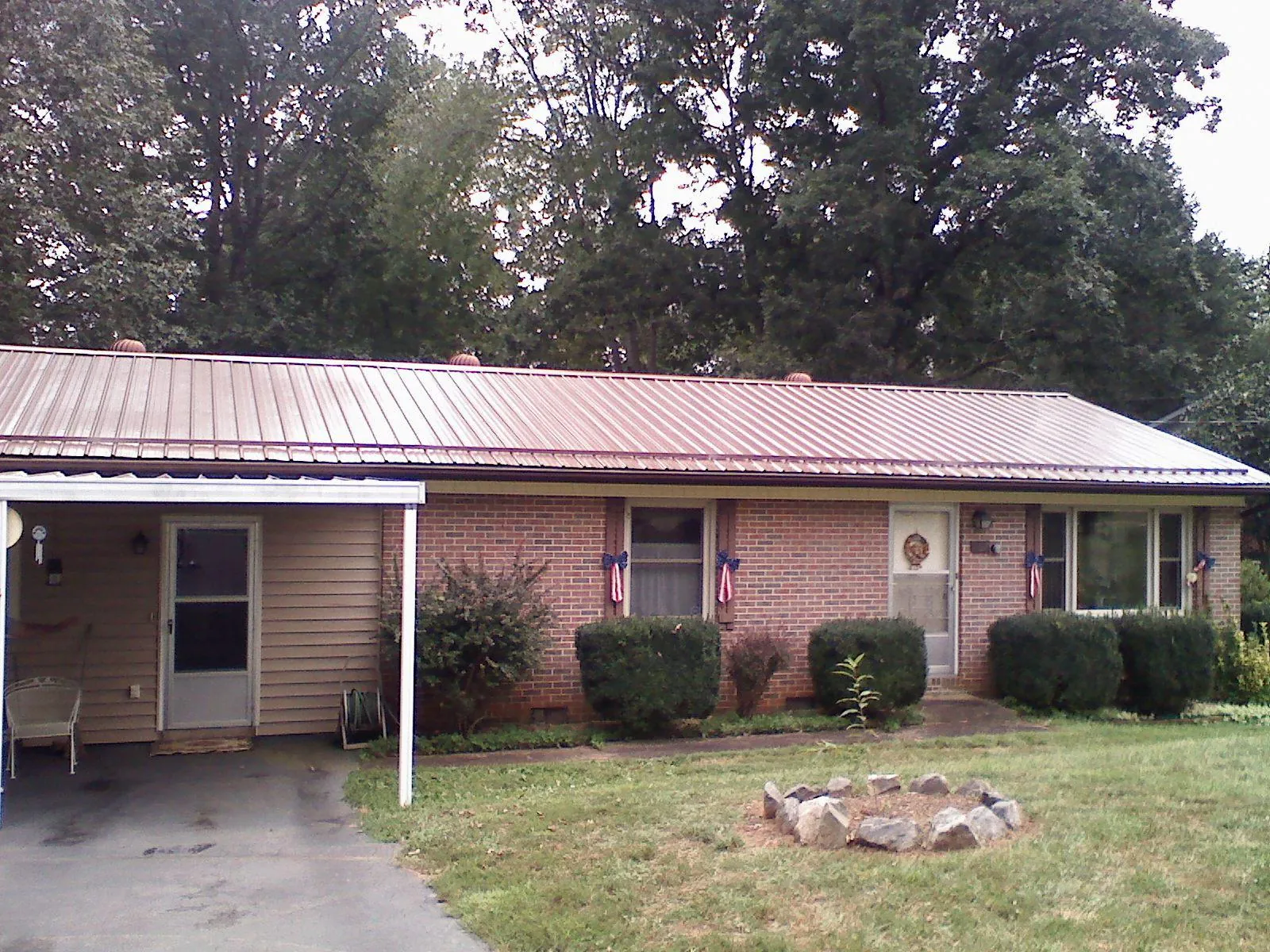 Bronze metal roof and carport on a brick ranch home — Roof Repair work by our crew in Waymart