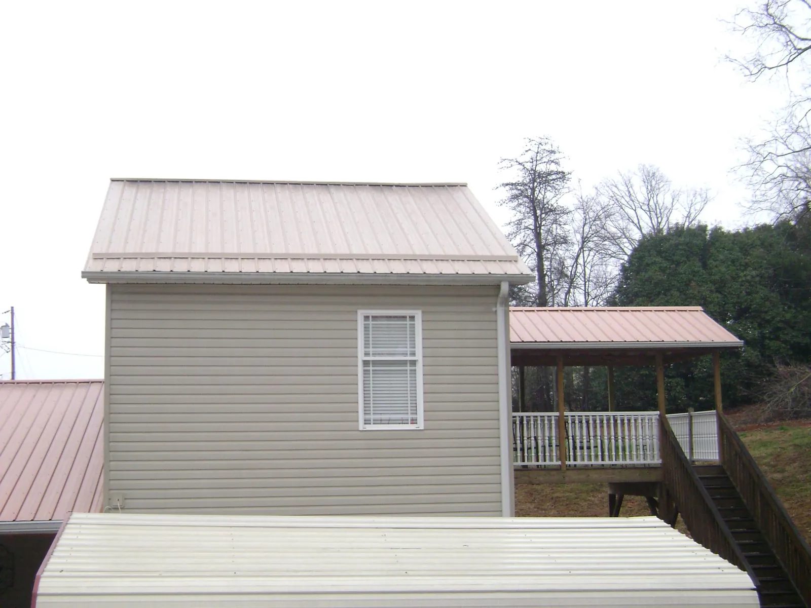 Tan metal roofs on a two story addition and attached porch, from a Roof Replacement job in Waymart